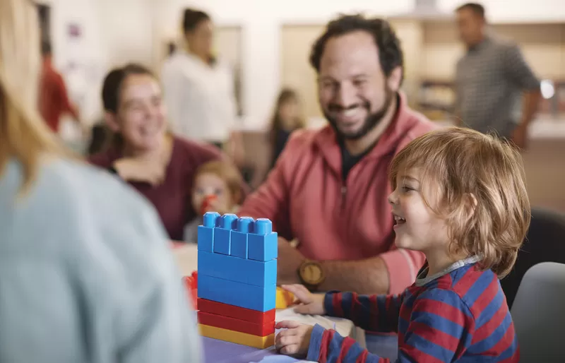 Staff and child playing with large legos