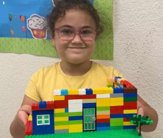 Little girl proudly shows off her lego house