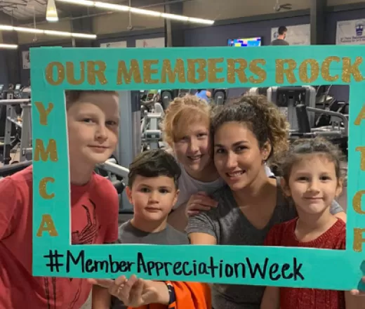 Members pose for a picture using a Member Appreciation photo frame.