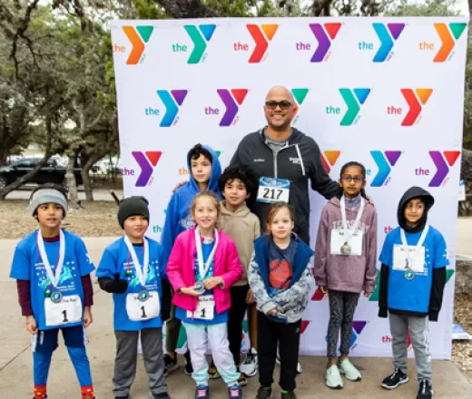 Family poses infront of a Y Logo Step & Repeat