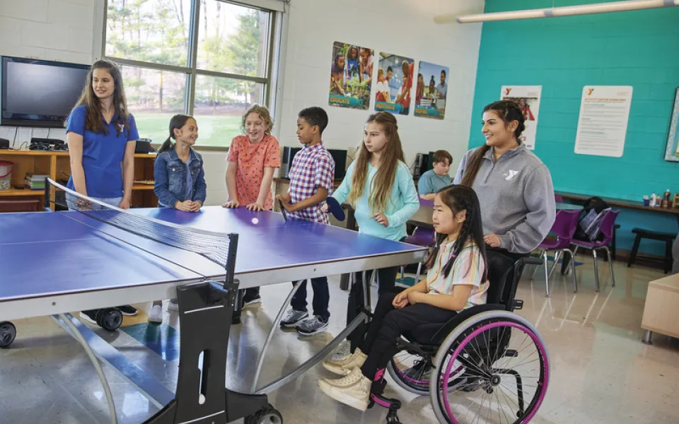 Child with Diverse-ability playing ping-pong with other kids